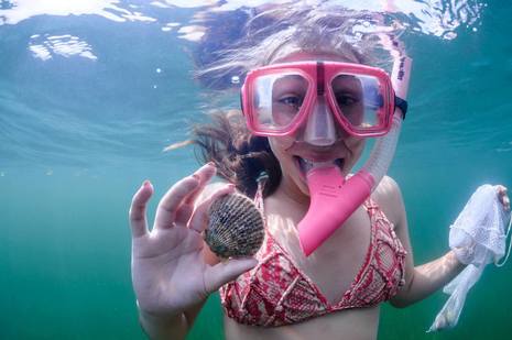 Underwater picture of a snorkeler and her scallop that she found!